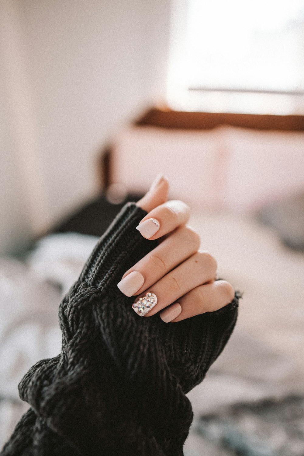A technician shaping a client's nail under the lamp at Daisy Nails & Spa